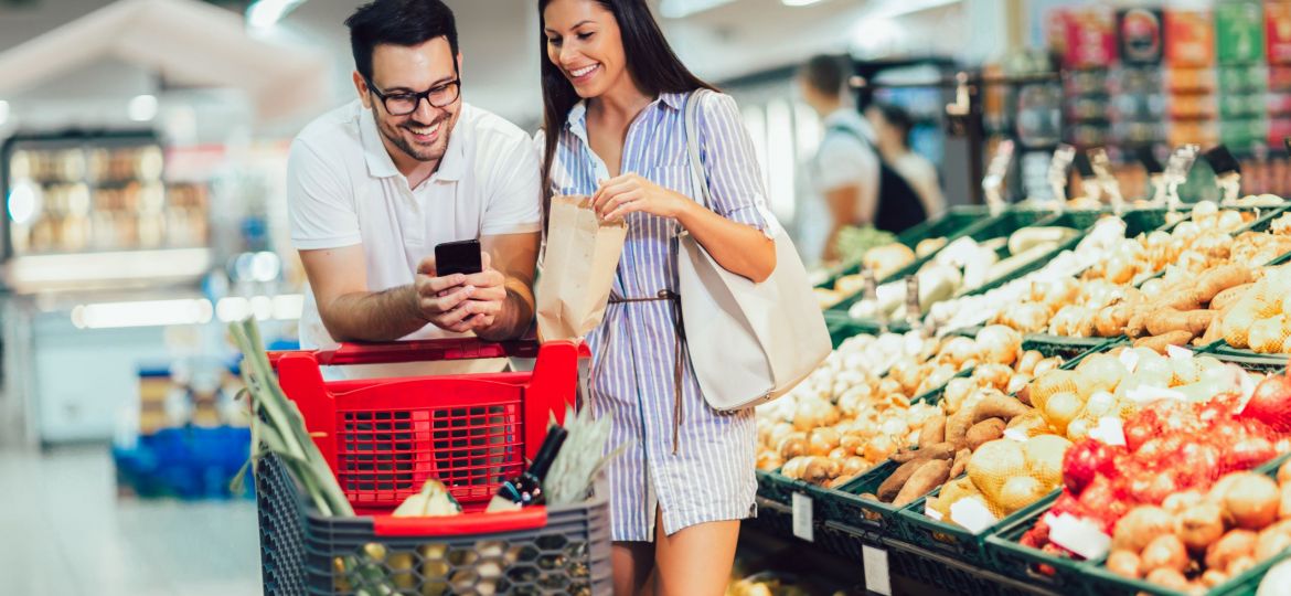 Happy couple buying vegetables at grocery store or supermarket